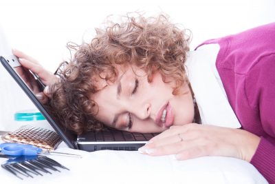Tired overworked business woman sleeps on laptop in office